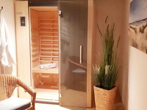 a door to a sauna with a plant in a room at Baltic Sea vacation-Bork in Kronsgaard