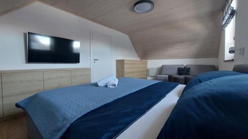 - une chambre avec un grand lit et une télévision à écran plat dans l'établissement Holiday House Sabala 3, à Stará Lesná