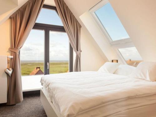 ein Schlafzimmer mit einem Bett und einem großen Fenster in der Unterkunft Reethuus Nord Modern retreat in Juist