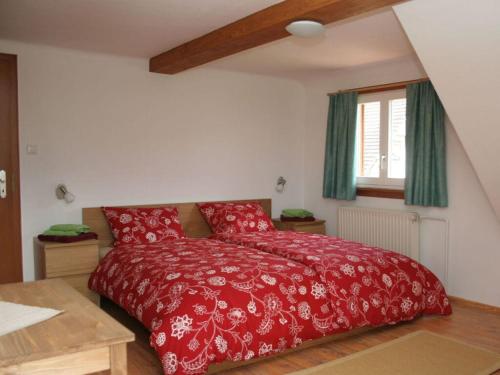 a bedroom with a red bed and a window at Gießler Modern retreat in Biberach