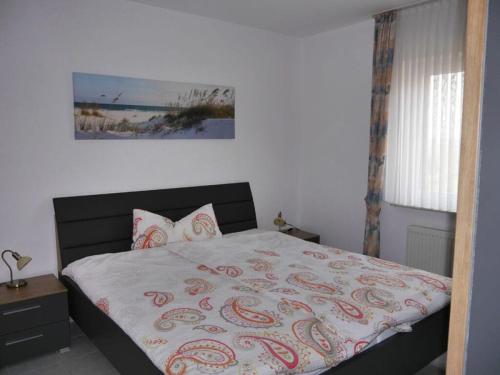1 dormitorio con 1 cama con manta y almohadas en Quellerweg 17 Merchant, en Horumersiel