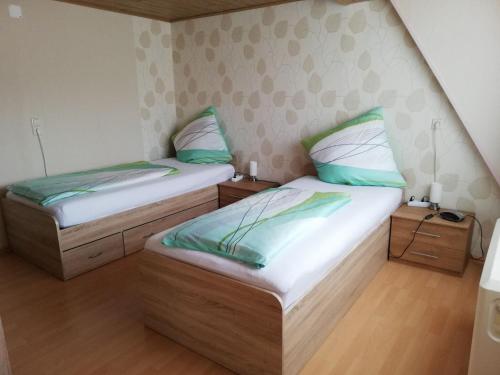 Habitación pequeña con 2 camas individuales y suelo de madera. en Imsbach am Donnersberg, 