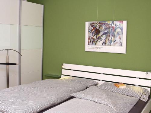 ein Schlafzimmer mit einem Bett mit einer grünen Wand in der Unterkunft Vacation in Oldenburg in Oldenburg