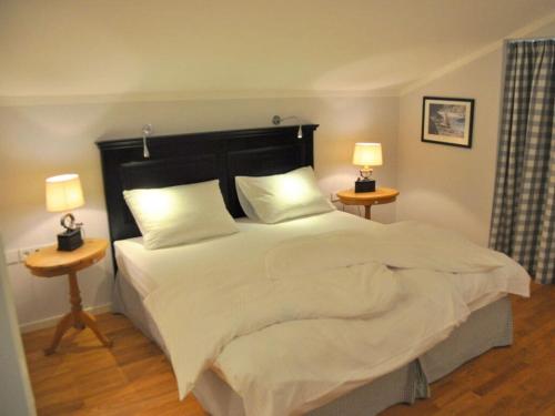 バート・ウィーゼにあるSuite Nuss Modern retreatのベッドルーム(白い大型ベッド、ランプ2つ付)