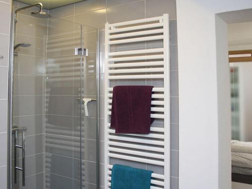 uma casa de banho com uma cabina de duche em vidro e uma toalha em Vacation in Oldenburg em Oldemburgo