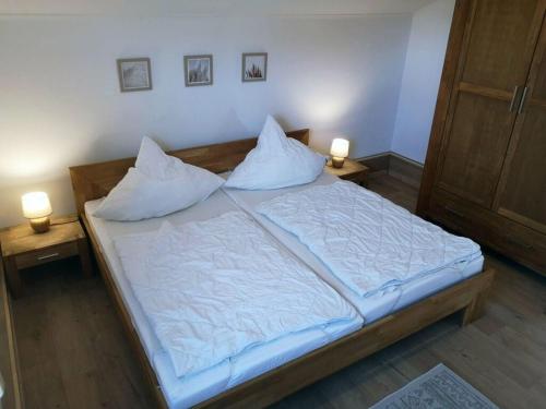 a bedroom with a large bed with two lamps on it at Seagull Street 21 Merchant in Horumersiel