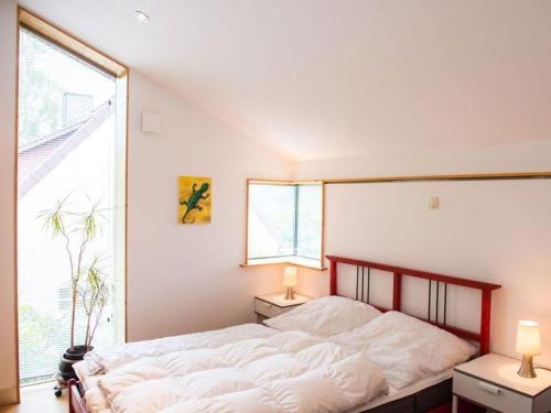 a bedroom with a large bed and a large window at House by the Park Modern retreat in Bispingen