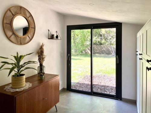 Habitación con espejo y tocador con una planta en Het kleine droomhuisje, en Vendays-Montalivet