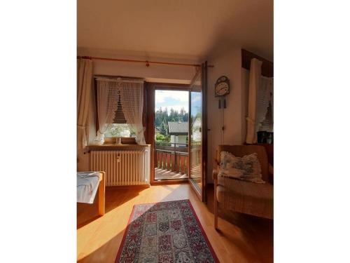 a living room with a door open to a balcony at Bärenhüsli No 7 in Titisee