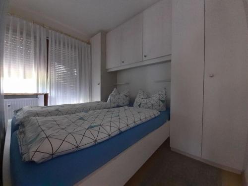 Schlafzimmer mit einem großen Bett und weißen Schränken in der Unterkunft Bärenhüsli No 4 in Titisee
