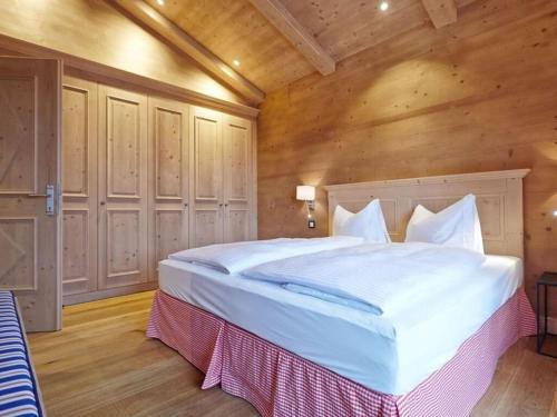 ein Schlafzimmer mit einem großen Bett in einem Holzzimmer in der Unterkunft Chestnut in chalet Bergerhöh in Bad Wiessee