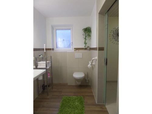 a bathroom with a toilet and a sink and a window at Bettis Bungalow Modern retreat in Bergen