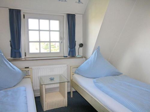 a small room with two beds and a window at Haus Ruusenhoog - Apartment 5 in Rantum