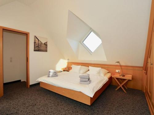 Schlafzimmer mit einem großen Bett und einem Dachfenster in der Unterkunft Peper Beach Street in Juist