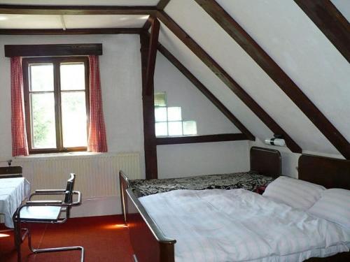 - une chambre mansardée avec un lit et deux chaises dans l'établissement Jaroslav Sevcik mountain hut, à Strážné
