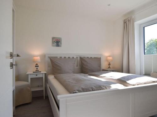 Un dormitorio blanco con una cama grande y una ventana en My Baltic Sea place house by the sea 9, en Niesgrau