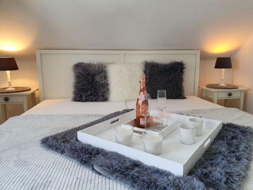 Bett mit einem Tablett mit einer Flasche Wein und Gläsern in der Unterkunft See & So Modern Retreat in Winterberg