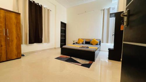 ein Wohnzimmer mit einem Sofa und gelben Kissen in der Unterkunft Atulyam Stays Sushant Golf City in Lucknow