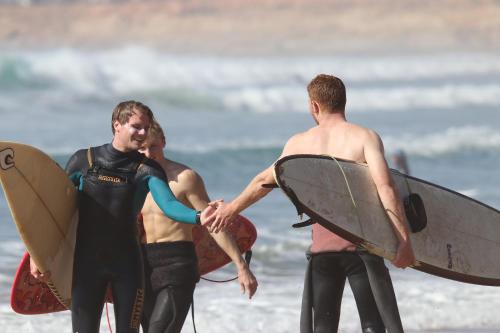 three men standing on the beach holding their surfboards at Sweet Taghazout Studios in Taghazout