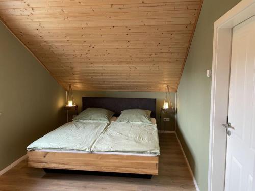 Posto letto in camera con soffitto in legno. di The Nordseehus Modern retreat a Dagebüll