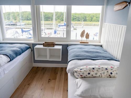 two beds in a room with two windows at Oceanhouse Modern Retreat in Den Oever