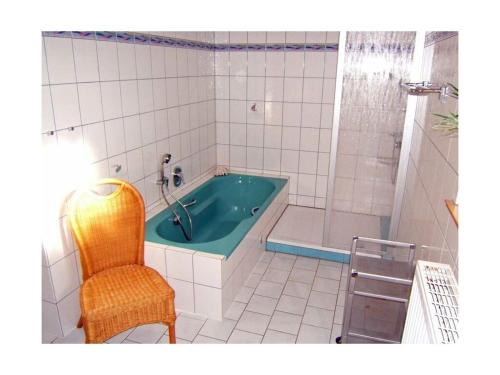 ein Badezimmer mit einer Badewanne und einem Stuhl in der Unterkunft Heinrich Tiarksstrasse 36 in Horumersiel