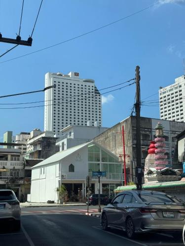 a car driving down a city street with tall buildings at LAIWAII HOME in Hat Yai