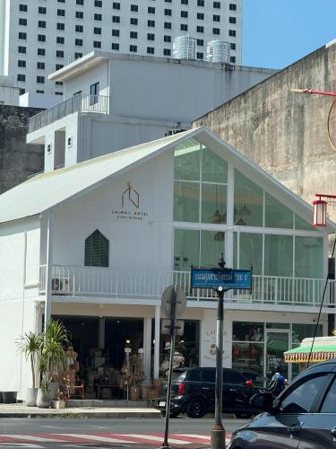 a white building with glass windows on a city street at LAIWAII HOME in Hat Yai