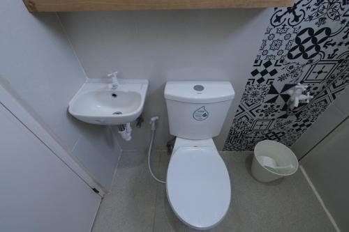 a small bathroom with a toilet and a sink at Villa Darroca Palawan in Araceli