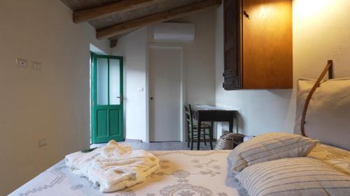 a bedroom with a bed with a green door at Andala agriturismo esperienziale in Samughèo