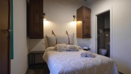 a bedroom with a bed with two shoes on it at Andala agriturismo esperienziale in Samughèo