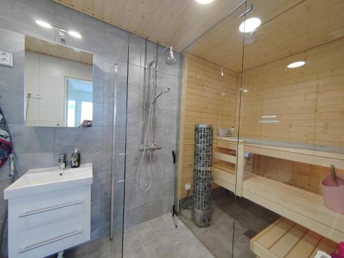 a bathroom with a shower and a sink at Casa di Sanna with Sauna & free parking in Vantaa