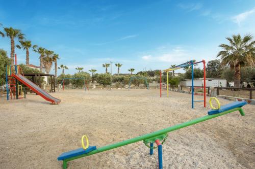 an empty playground with a slide and swings at Eurovillage Achilleas Hotel in Mastichari