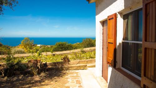a window of a house with a view of the ocean at Welcomely - Badde Nuraghe dimora vista mare con parcheggio privato in Magomadas