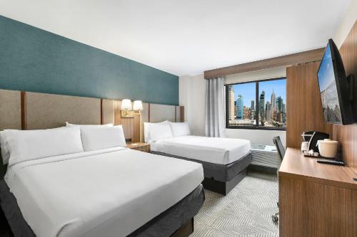 ニューヨークにあるホリデイイン マンハッタン シックスアベニュー チェルシーのベッド2台と窓が備わるホテルルームです。