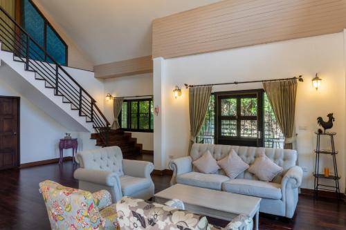 a living room with a couch and chairs at NiRVANA Khao Kho วิลล่าพักผ่อนสำหรับ 8 ท่าน ติดวัดผาซ่อนแก้ว เดิน 5 นาที สัมผัสบรรยากาศอบอุ่น เหมือนได้กลับมารวมตัวกันอีกครั้ง in Phetchabun