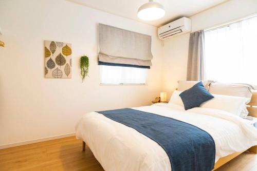 a bedroom with a large bed and a window at 海まで徒歩30秒！人気の北谷エリアでまるまる一棟ゆったり貸し切り！ in Hamakawa