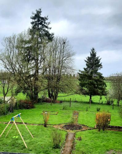 a garden with a swing set in the grass at La Villa Beausejour in Baives