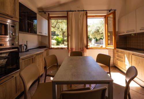 a kitchen with a table and chairs in it at Welcomely - Badde Nuraghe dimora vista mare con parcheggio privato in Magomadas