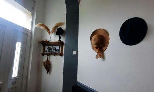 a hallway with hats on the wall and a window at La Villa Beausejour in Baives