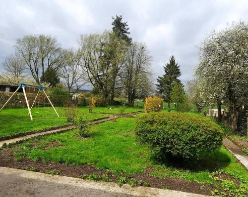 a park with a swing set in the grass at La Villa Beausejour in Baives