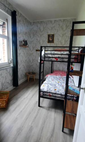 a bedroom with two bunk beds and a wooden floor at La Villa Beausejour in Baives