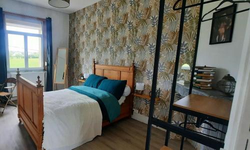 a bedroom with a bed with blue pillows on it at La Villa Beausejour in Baives