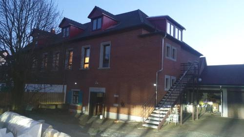 un gran edificio de ladrillo rojo con una escalera. en Kalinka 90766 Fürth en Fürth