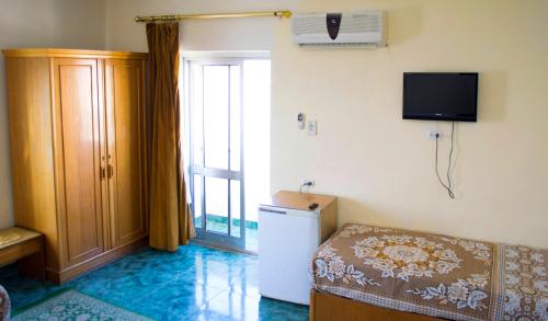 Semiramis hotel في الإسكندرية: غرفة بها سرير وتلفزيون على الحائط