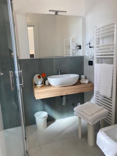 een badkamer met een witte wastafel en een douche bij Hotel Londra in Milano Marittima