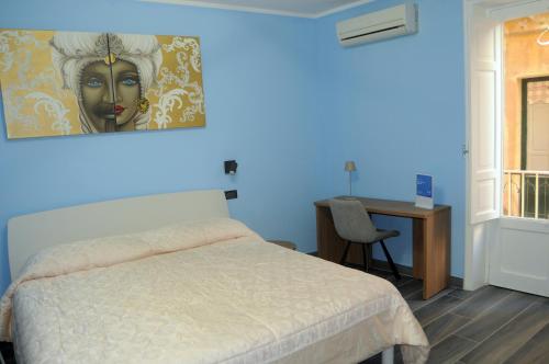 um quarto com uma cama com um quadro na parede em Appartamento Badiella em Trapani