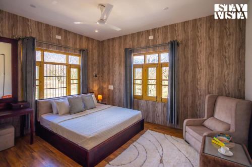 - une chambre avec un lit, un canapé et des fenêtres dans l'établissement StayVista at The Dewan Bagh, à Srinagar