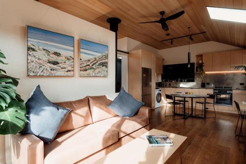 a living room with a couch and a table at Poets corner cottage in Surf Beach