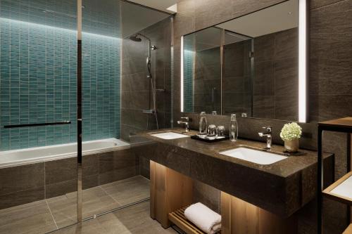 a bathroom with two sinks and a large mirror at TIAD, Autograph Collection in Nagoya